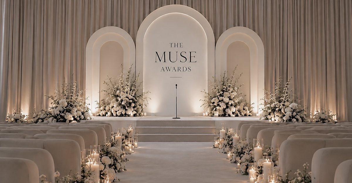 Mood image: a candlelit aisle between rows of velvet seats leading to a white stage with flowers